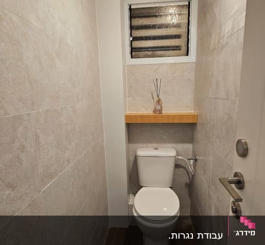 Small bathroom with wooden shelf above toilet